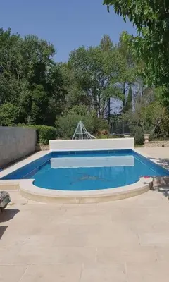 a large swimming pool in a yard at La Villa St Antoine in LʼIsle-sur-la-Sorgue