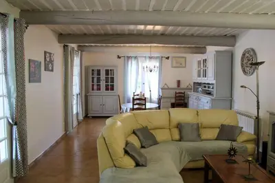 a living room with a yellow couch and a table at La Villa St Antoine in LʼIsle-sur-la-Sorgue