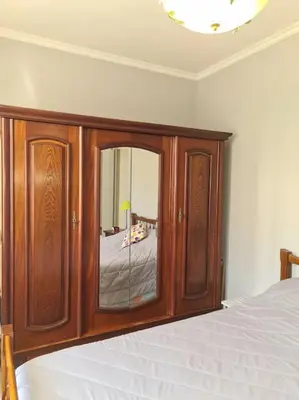 a bedroom with a wooden cabinet with a mirror at La Villa St Antoine in LʼIsle-sur-la-Sorgue
