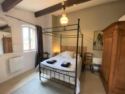 a bedroom with a four poster bed in a room at Le Perchoir in Mérindol