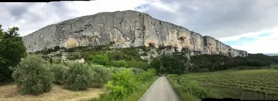 a road in front of a large rock formation at Le Perchoir in Mérindol