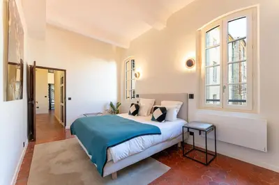a bedroom with a large bed with a blue blanket at La Suite 26 - Appartement Art & Design in Aix-en-Provence