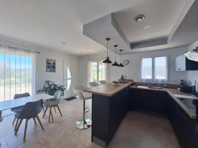 a kitchen and dining room with a table and chairs at Gîte l'olivier in Sainte-Tulle