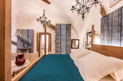 a bedroom with a large bed and a chandelier at L'unique in Goult