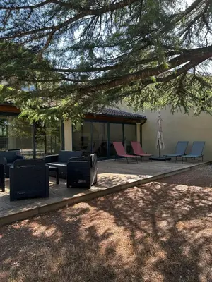 a group of chairs and tables in front of a building at Mazet des Cèdres au pied de la colline in Lagnes