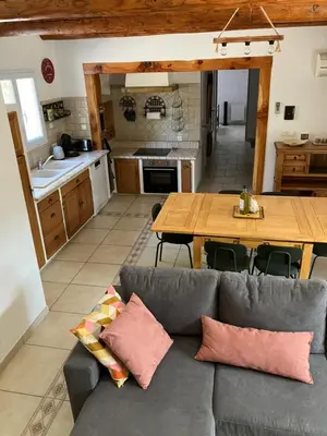 a living room with a couch and a wooden table at Mazet des Cèdres au pied de la colline in Lagnes