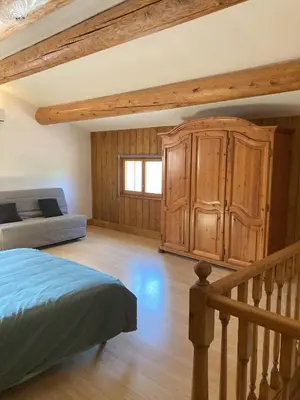 a bedroom with a bed and a wooden cabinet at Mazet des Cèdres au pied de la colline in Lagnes