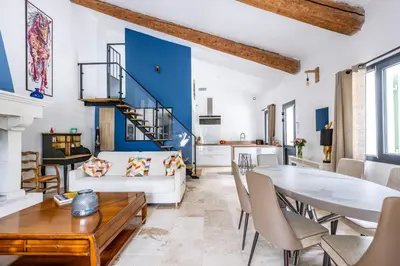 a living room with a white couch and a table at Gîte Le Figuier des Alpilles- 6p in Eygalières
