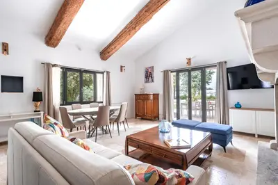 a living room with a couch and a table at Gîte Le Figuier des Alpilles- 6p in Eygalières