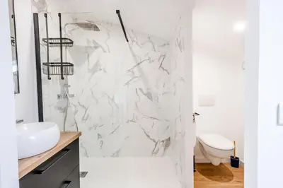 a white bathroom with a shower and a sink at Gîte Le Figuier des Alpilles- 6p in Eygalières