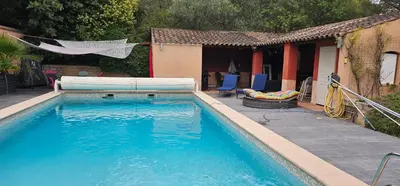a swimming pool with a bench next to a house at Appartement à La Bastidonne in La Bastidonne
