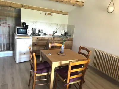 a kitchen with a wooden table and chairs in a kitchen at La Respelido studio ds maison campagne in Cabannes