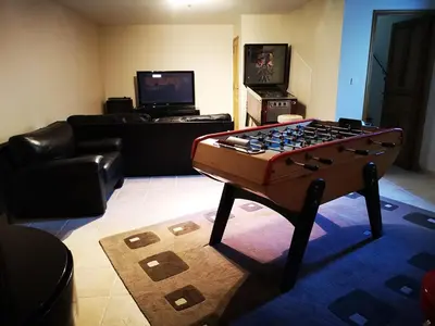 a living room with a foosball table in the middle of a room at La Colline, villa avec piscine in Châteaurenard