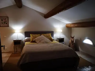 a bedroom with a large bed with two lamps at La Colline, villa avec piscine in Châteaurenard