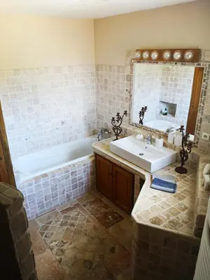 a bathroom with a sink and a tub and a mirror at La Colline, villa avec piscine in Châteaurenard