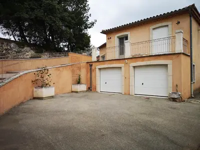 a house with four garage doors in front of it at La Colline, villa avec piscine in Châteaurenard