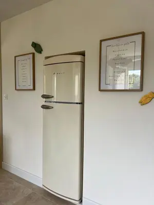 a refrigerator in a room with a picture on the wall at Oustau di Gaffo in LʼIsle-sur-la-Sorgue