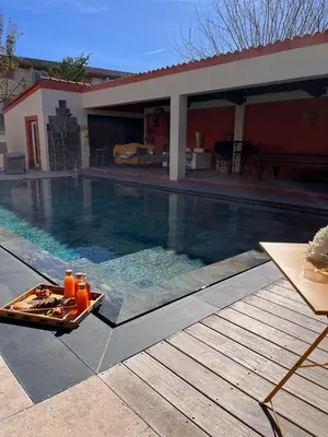 a tray of drinks sitting next to a swimming pool at Le Mas d'Emilienne in Coudoux