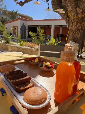 a table with a tray of breakfast foods and a drink at Le Mas d'Emilienne in Coudoux
