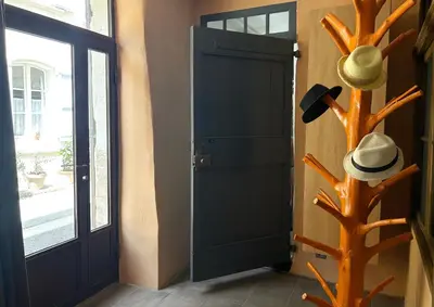 a door with a fake tree with hats on it at La Cigalou - Bonnieux Centre in Bonnieux