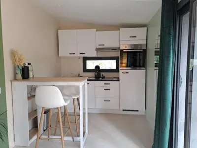 a kitchen with white cabinets and a table and chairs at La Pinède de Venelles Jacuzzi privatif in Venelles