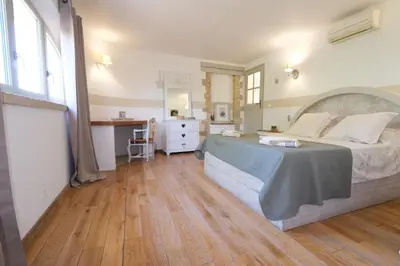 a bedroom with a large bed and a wooden floor at Charming Provencal Mas with pool by Taillades, close to Cavaillon in the Luberon, sleeps 6. in Les Taillades