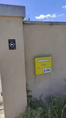 a yellow mailbox on the side of a wall at Au Petit Luberon in Cheval-Blanc
