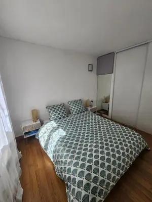 a bedroom with a bed with a black and white comforter at Le Mazet des Beaujots in Monteux
