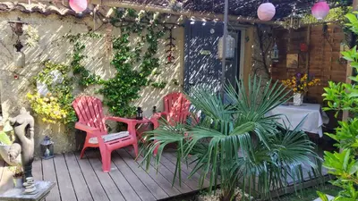 two chairs and a table on a deck with plants at Le Mazet des Beaujots in Monteux