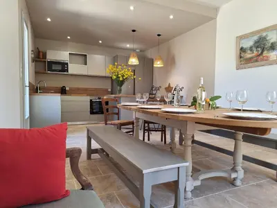 a dining room and kitchen with a table and chairs at Mas Les Figuières in Monteux