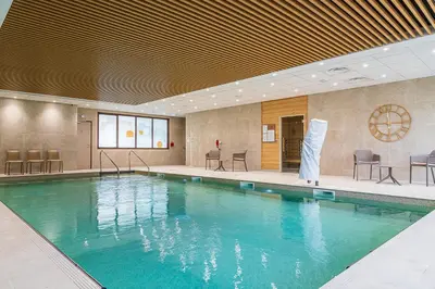 a swimming pool with blue water in a building at DOMITYS - L'Amandier in Aix-en-Provence