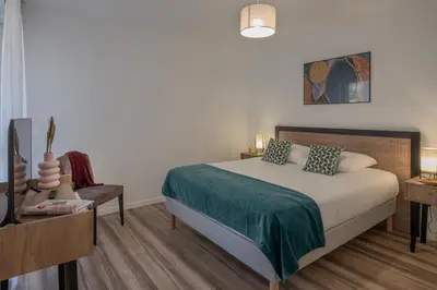 a bedroom with a bed and a table and a chair at DOMITYS - L'Amandier in Aix-en-Provence