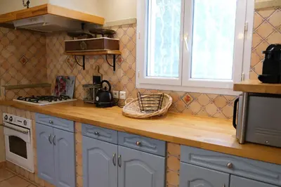 a kitchen with blue cabinets and a counter top at Air-conditioned house with heated pool, Luberon, in Maubec – 6 people in Maubec