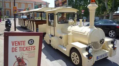 an old train car is parked next to a sign at Logement studio avec vue sur le centre Historique in LʼIsle-sur-la-Sorgue