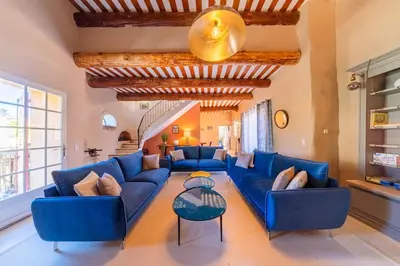 a living room with blue couches and a table at Ancien Moulin avec piscine proche Isle-sur-Sorgue in Le Thor