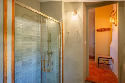 a bathroom with a glass shower with blue tiles at Ancien Moulin avec piscine proche Isle-sur-Sorgue in Le Thor