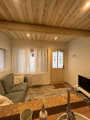 a living room with a couch and a tv at Le cocon d Elsa in LʼIsle-sur-la-Sorgue