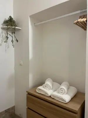 a room with three towels on a wooden shelf at Le cocon d Elsa in LʼIsle-sur-la-Sorgue