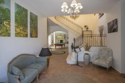 a living room with a couch and a staircase at superb prestige property with indoor heated swimming pool, seminar room and tennis court in mouries, in the alpilles in provence – 16 people in Mouriès
