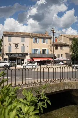 a bridge over a street with buildings and cars at Le Partage des eaux - 4 couchages - Hypercentre - Clim - Wifi in LʼIsle-sur-la-Sorgue