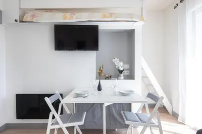 a white dining room with a white table and chairs at Le Partage des eaux - 4 couchages - Hypercentre - Clim - Wifi in LʼIsle-sur-la-Sorgue