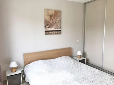a bedroom with a white bed and two night stands at Gite de charme avec piscine dans le Luberon in Cavaillon