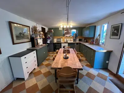 a large kitchen with a wooden table in it at Maison de charme provençale en pierre in Puyvert