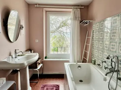 a bathroom with a sink and a tub and a window at L' Escale in Bonnieux