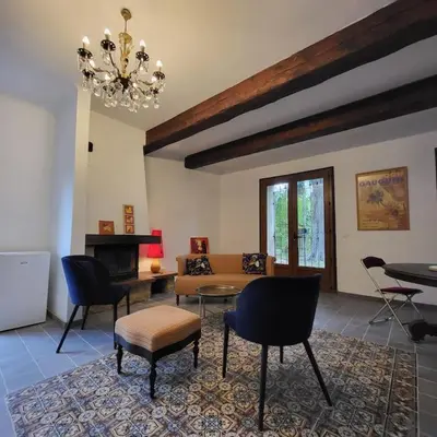 a living room with a couch and chairs and a chandelier at L' Escale in Bonnieux