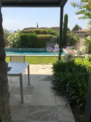 a bench sitting on a patio next to a pool at Le Clos de Yann in Gordes