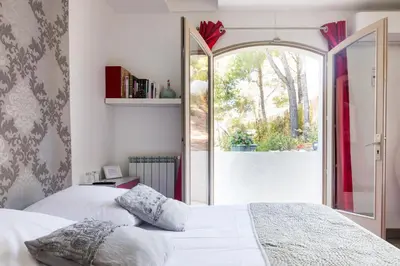 a bedroom with a bed and a large window at Villa Le Mas des Roches à 15mn airport Marseille in Velaux