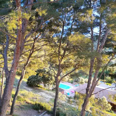 a view of a house in the middle of trees at Villa Le Mas des Roches à 15mn airport Marseille in Velaux