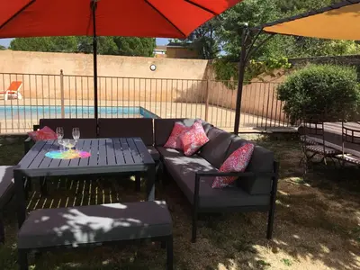 a patio with a couch and a table and an umbrella at les couleurs du sud in Aix-en-Provence