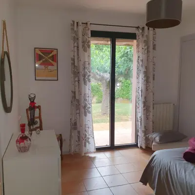 a bedroom with a sliding glass door to a yard at les couleurs du sud in Aix-en-Provence